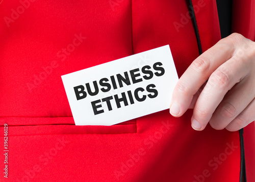 Businessman puts a card with text BUSINESS ETHICS in his pocket, business concept