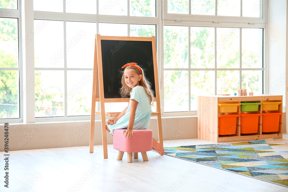 Cute little girl near blackboard in kindergarten Cute little girl near blackboard in kindergarten