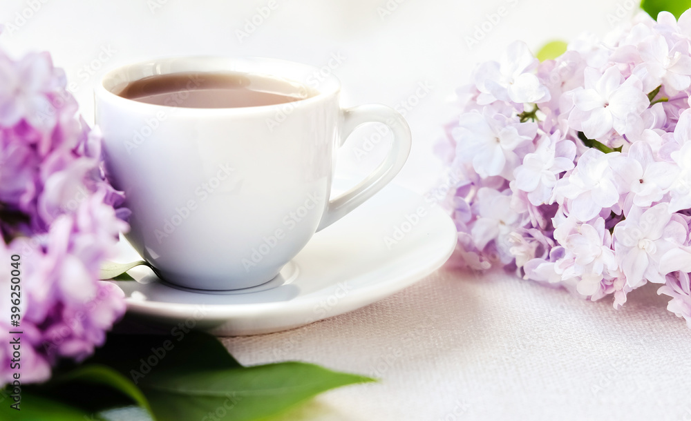 white coffee Cup with branch of lilac on white background. The concept of tenderness and celebration of Valentine's day white coffee Cup with branch of lilac on white background. The concept of tenderness and celebration of Valentine's day