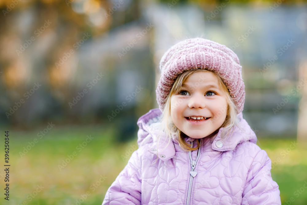 Portrait of adorable cute toddler girl of three years. Beautiful baby with blond hairs looking and smiling at the camera. Happy healthy child in winter stylish clothes outdoors. Portrait of adorable cute toddler girl of three years. Beautiful baby with blond hairs looking and smiling at the camera. Happy healthy child in winter stylish clothes outdoors.