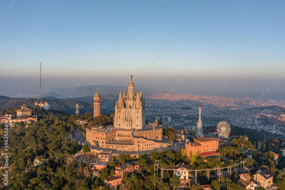 Fototapeta premium Aerial drone view of Basilica Sacred Heart on Mount Tibidabo near Barcelona during sunset golden hour
