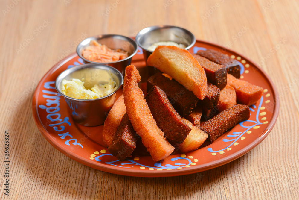 Crouton stack in a porcelain plate with different kinds of sauce. Delicious snack for beer. Crouton stack in a porcelain plate with different kinds of sauce. Delicious snack for beer.