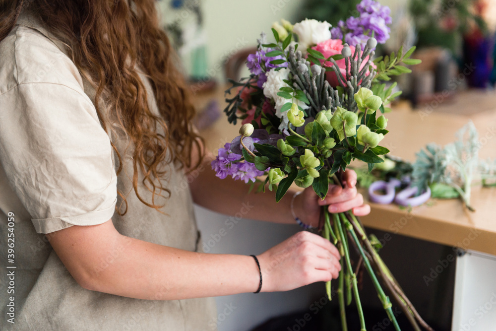 Young woman florist work with flowers at workplace, small business concept, lifestyle, cropped portrait, flowers close up Young woman florist work with flowers at workplace, small business concept, lifestyle, cropped portrait, flowers close up