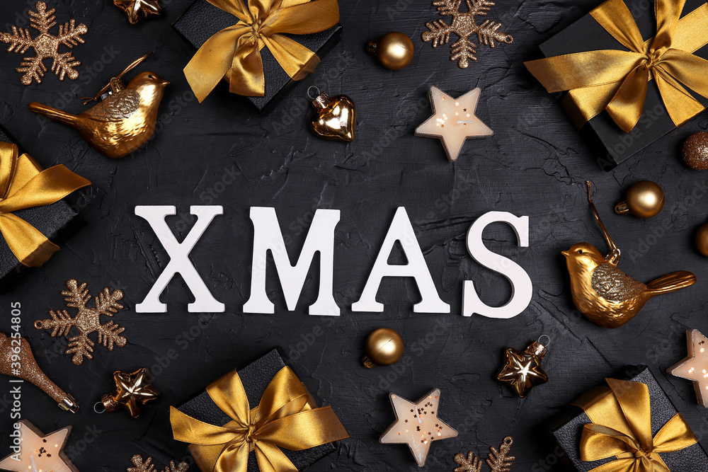 The word Xmas surrounded by golden ornaments and gifts on a black background. The word Xmas surrounded by golden ornaments and gifts on a black background.