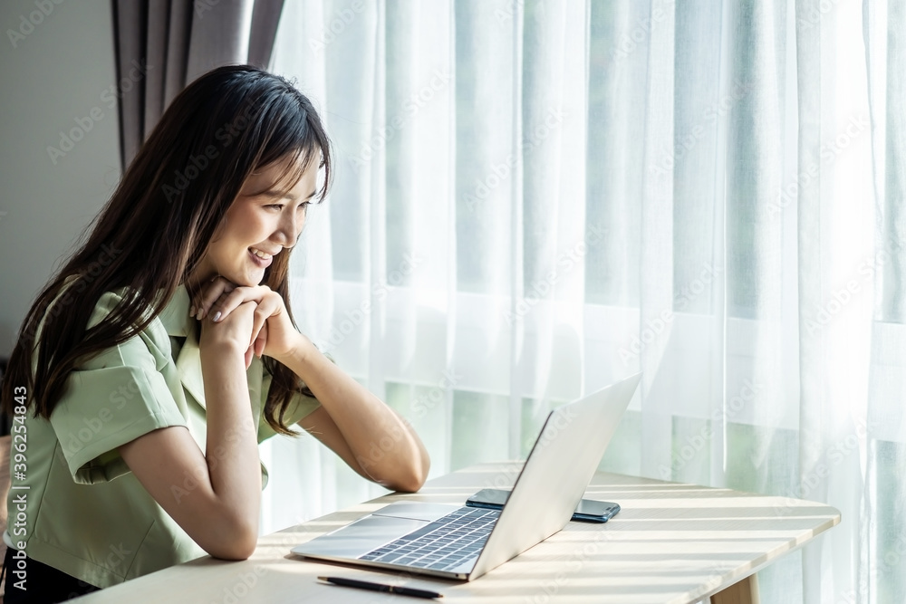Smiling young asian woman using laptop in home, beautiful girl shopping or chatting online in social network, having fun, watching movie, freelancer working on computer project Smiling young asian woman using laptop in home, beautiful girl shopping or chatting online in social network, having fun, watching movie, freelancer working on computer project
