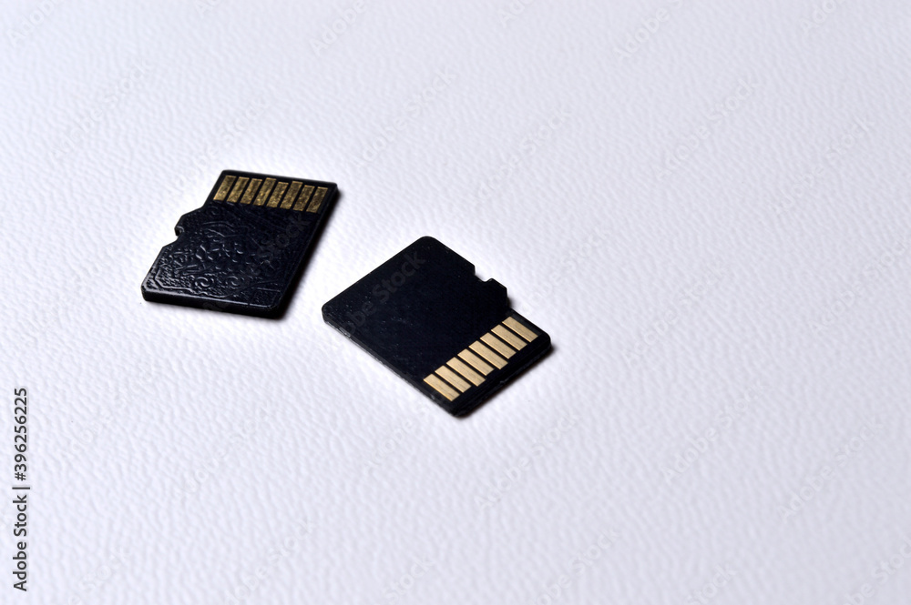 two micro sd cards on a white plastic background. close-up. two micro sd cards on a white plastic background. close-up.