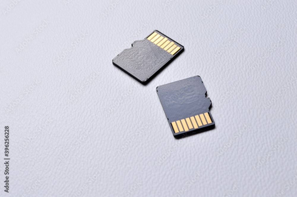 two micro sd cards on a white plastic background. close-up. two micro sd cards on a white plastic background. close-up.