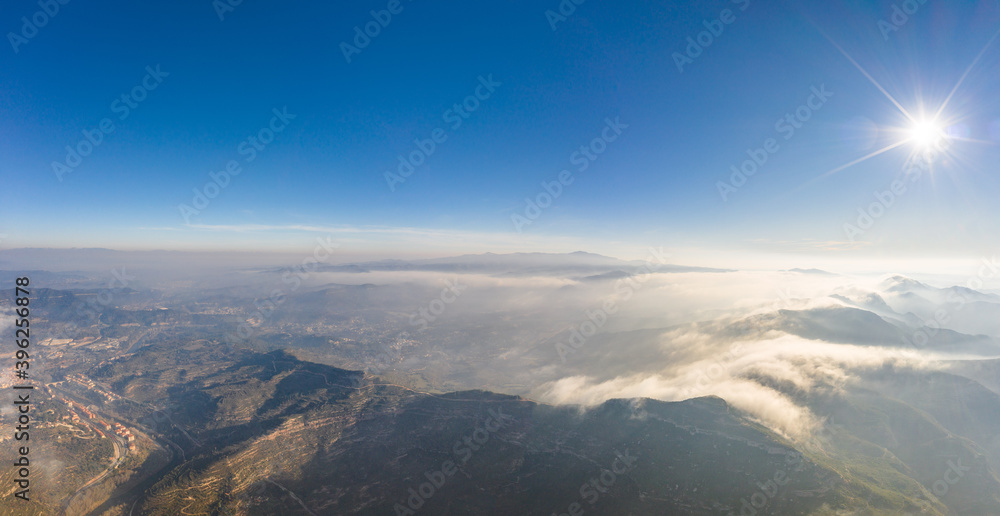 Panoramic aerial drone view of fogs over mountain in Montserrat Barcelona in morning