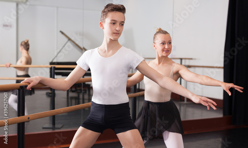 Beautiful woman and teenager poses near mirror in hall with ballet bar. High quality photo