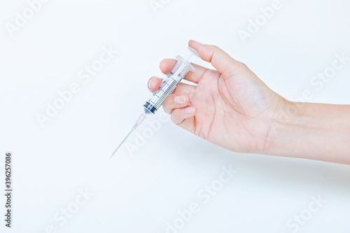 New syringe in girl hand on white background, healthcare concept