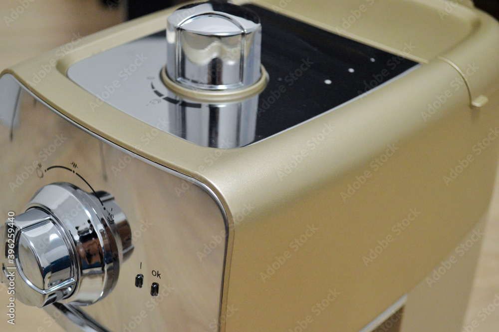 Modern beige coffee machine stands on a wooden background. Modern beige coffee machine stands on a wooden background.
