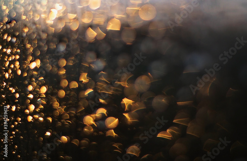 raindrops on the window in the light of the sun, reminiscent of Christmas lights