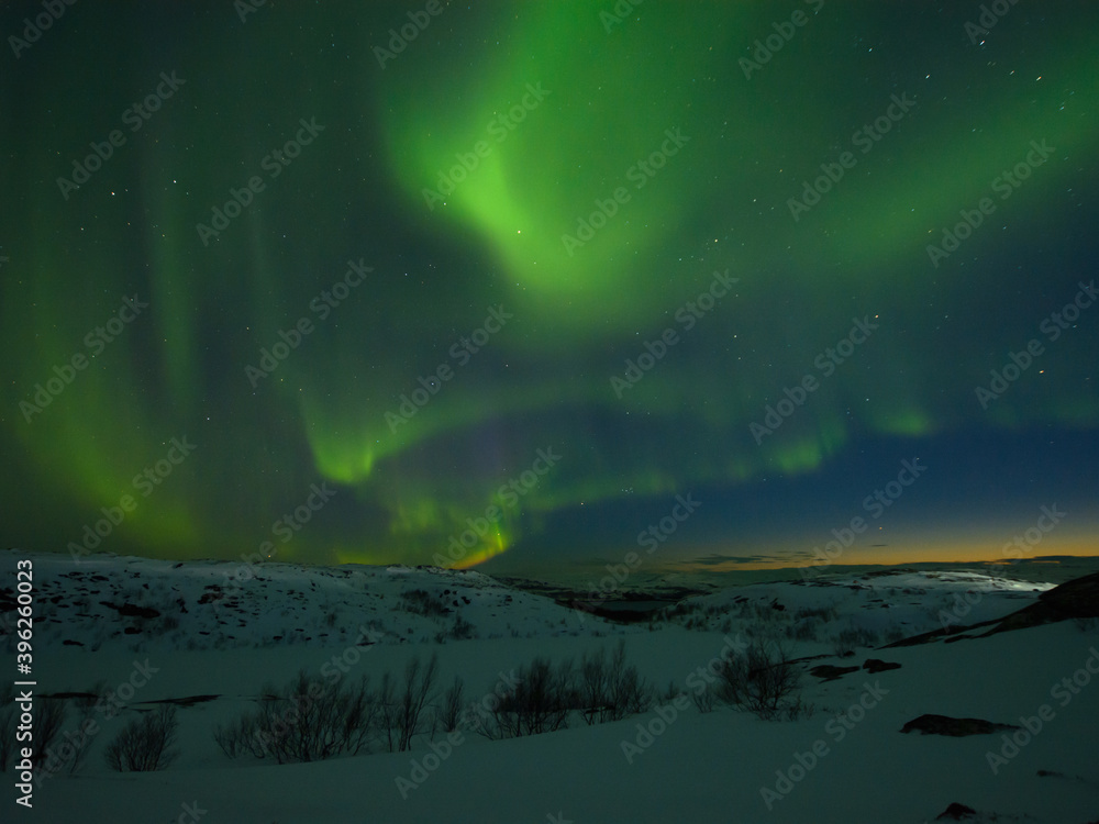 Night sky . Northern Lights . Hills in winter. Large stones.