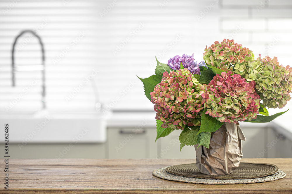 Bouquet of hydrangeas on the kitchen table close up on a blurred background.