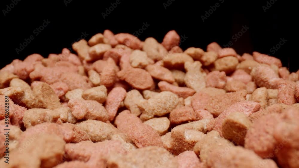 MACRO: Motion over cat food on a black background MACRO: Motion over cat food on a black background
