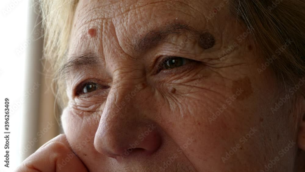 An old man or woman looks thoughtfully and sadly into the distance. Close-up of wrinkles on the face. Loneliness in self-isolation during quarantine An old man or woman looks thoughtfully and sadly into the distance. Close-up of wrinkles on the face. Loneliness in self-isolation during quarantine