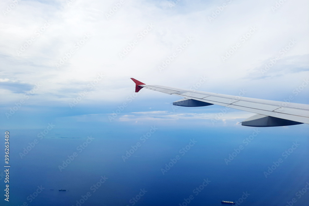 Fototapeta premium A beautiful view of blue ocean with ship viewed from an airplane window