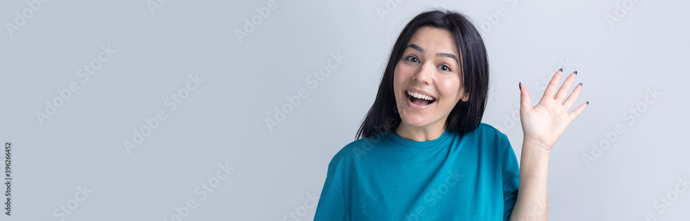 Smiling woman raised her hand palm up and forward like waving. Smiling woman raised her hand palm up and forward like waving.
