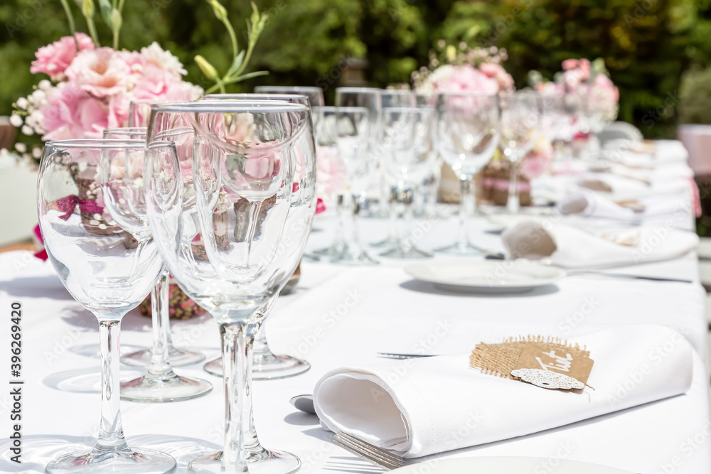 Wedding table decorated with bouquet of pink flowers and wine glasses
