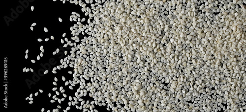 Sesame seeds pile isolated on black background, top view