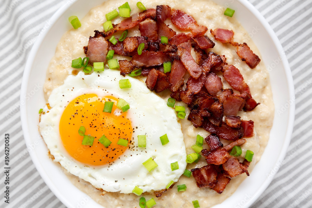 Homemade Cheesy Bacon Savory Oatmeal Bowl on cloth, top view. Overhead, from above, flat lay. Close-up. Homemade Cheesy Bacon Savory Oatmeal Bowl on cloth, top view. Overhead, from above, flat lay. Close-up.