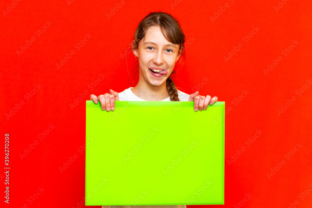 Young self-satisfied caucasian teenager girl holding blank paper sheet over red background. Young self-satisfied caucasian teenager girl holding blank paper sheet over red background.