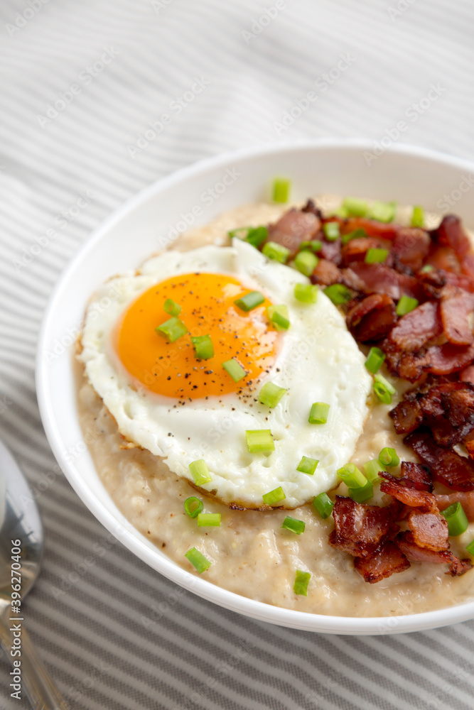 Homemade Cheesy Bacon Savory Oatmeal Bowl on cloth, low angle view. Homemade Cheesy Bacon Savory Oatmeal Bowl on cloth, low angle view.
