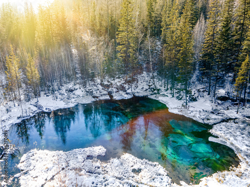 фотографія Beautiful amazing landscape of mountain ice-free lake surrounded by a winter forest