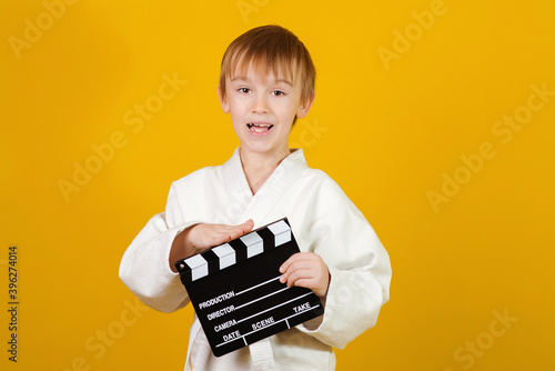 Cute boy making video or movie. Little actor over yellow background. Kids hobby and leisure concept.