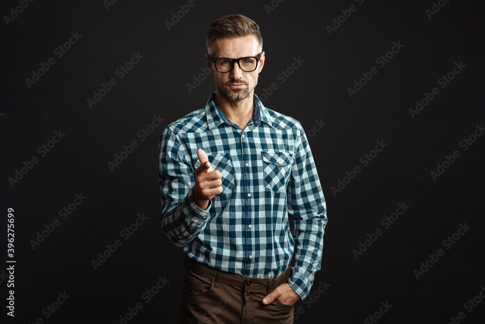 Handsome confident man pointing finger and looking at camera