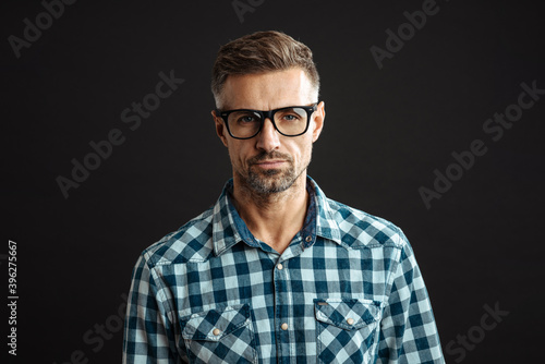 Handsome confident man in eyeglasses posing and looking at camera