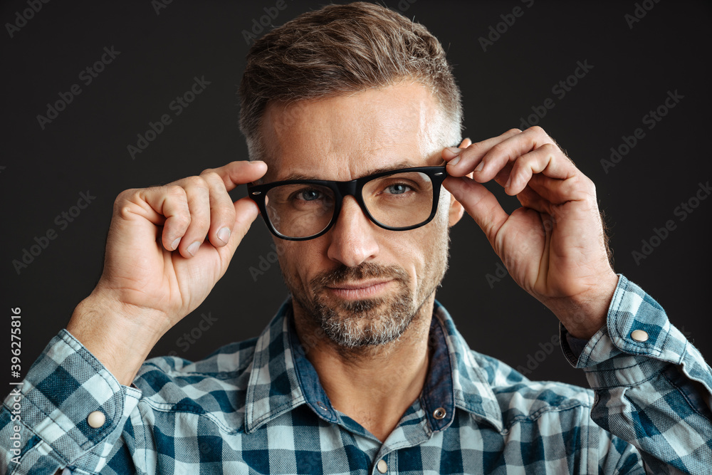 Handsome confident man in eyeglasses posing and looking at camera Handsome confident man in eyeglasses posing and looking at camera