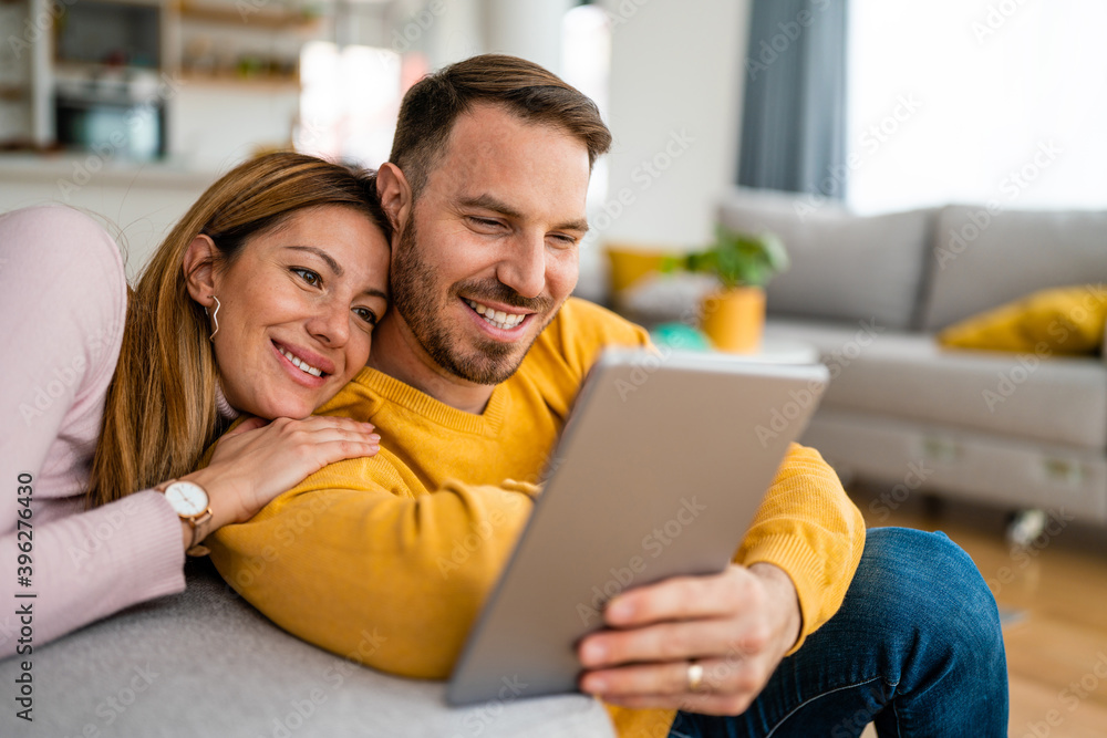Couple in love hugging and using tablet together. Couple in love hugging and using tablet together.