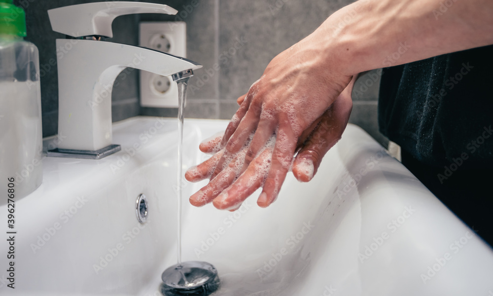 close up. young man is carefully soaping his hands . close up. young man is carefully soaping his hands .
