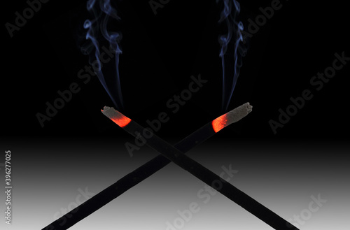 A pair of Incense sticks and smoke. photo