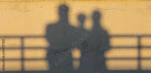 Shadow of a family on wall during sunset