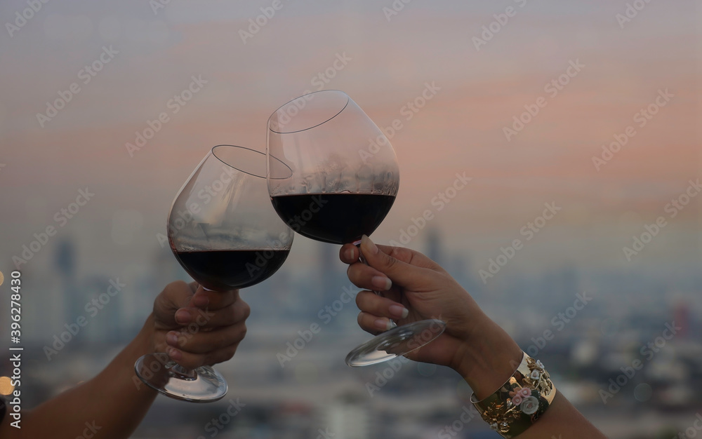 Happy lifestyle Romantic of couple which happy moment relaxing with red wineglass,celebration on the rooftop and sunset sky scene