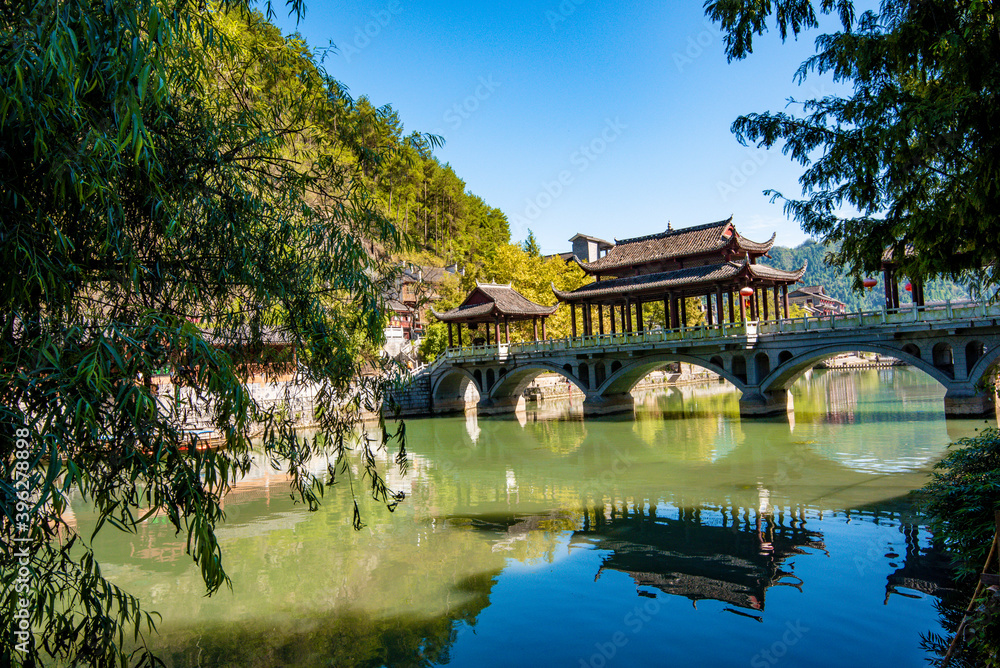 the river, the boat, stone bridge and the old houses at ancient phoenix town in the morning at Hunan, China.