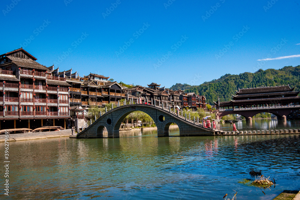 Obraz premium the river, the boat, stone bridge and the old houses at ancient phoenix town in the morning at Hunan, China.
