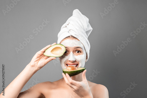 portrait of a young woman applying natural avocado mask on her face. Face Skin Care. Cleansing Procedure. Cosmetology. Skincare cleansing eco organic photo
