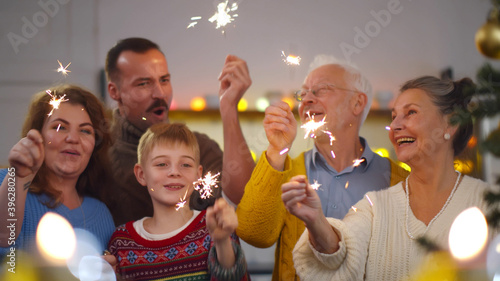 Canvas Print Cheerful family with different ages holding sparkles celebrating christmas
