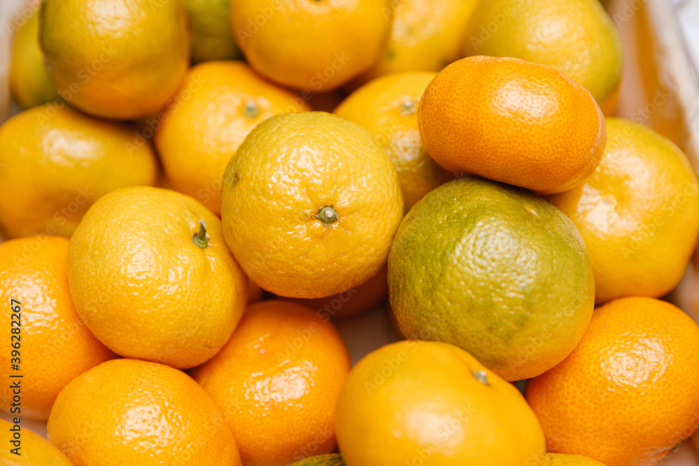 Fresh mandarins on fruit market, close up. Boxes full of ripe mandarin oranges for sale on farmers market. Fresh fruit display in shop. Juicy mandarin orange at the greengrocer's stall. Fresh mandarins on fruit market, close up. Boxes full of ripe mandarin oranges for sale on farmers market. Fresh fruit display in shop. Juicy mandarin orange at the greengrocer's stall.