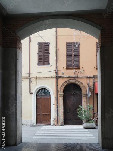 Ferrara, Italy. Facade of a building seen from under a colonnade.