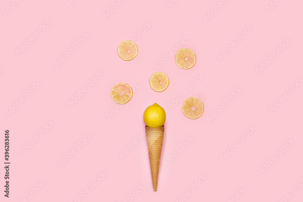 Cono de oblea con un limón y rodajas sobre un fondo rosa liso y aislado. Vista superior. Copy space Cono de oblea con un limón y rodajas sobre un fondo rosa liso y aislado. Vista superior. Copy space