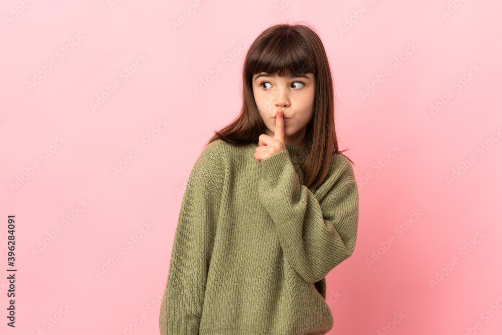Little girl isolated on pink background showing a sign of silence gesture putting finger in mouth Little girl isolated on pink background showing a sign of silence gesture putting finger in mouth