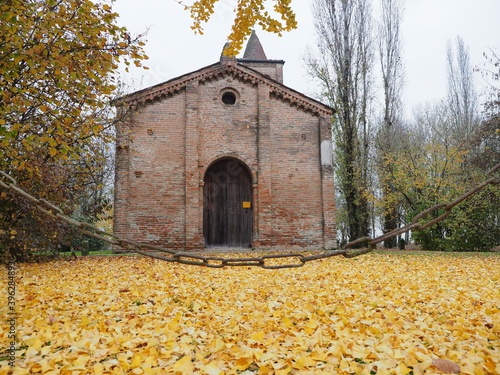 Copparo, Italy. Santa Maria di Savonuzzo Romanesque church, also called Pieve di San Venanzio. It was built in 1344 at the behest of the feudal lord Giovanni da Saletta. Foliage. photo