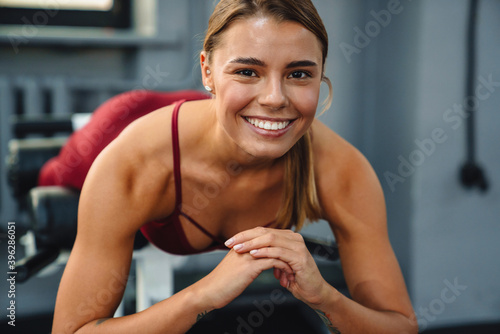 Fototapeta Naklejka Na Ścianę i Meble -  Sportswoman doing exercise on fitness equipment while working out