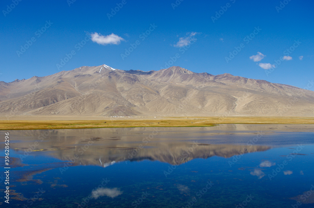 Spectacular panoramic view of mountain reflection in high-altitude Bulunkul lake near the Pamir Highway in Gorno-Badakshan, Tajikistan Spectacular panoramic view of mountain reflection in high-altitude Bulunkul lake near the Pamir Highway in Gorno-Badakshan, Tajikistan