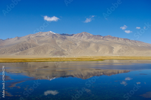 Spectacular panoramic view of mountain reflection in high-altitude Bulunkul lake near the Pamir Highway in Gorno-Badakshan, Tajikistan