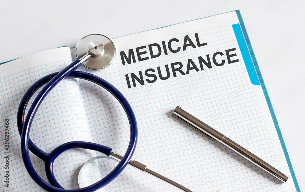 Paper with text MEDICAL INSURANCE on a table with stethoscope Paper with text MEDICAL INSURANCE on a table with stethoscope